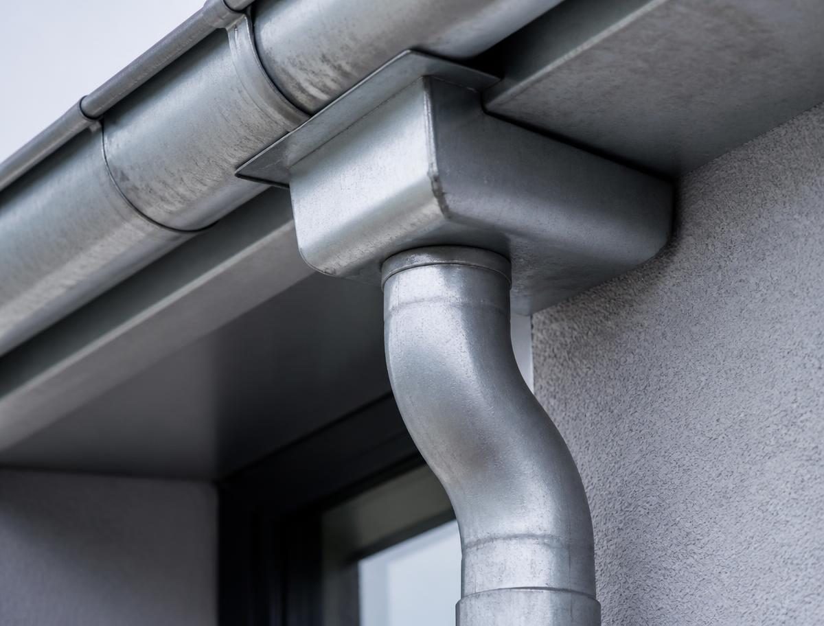 Metallischer Rinnenkessel mit Fallrohranschluss an einer Fassade