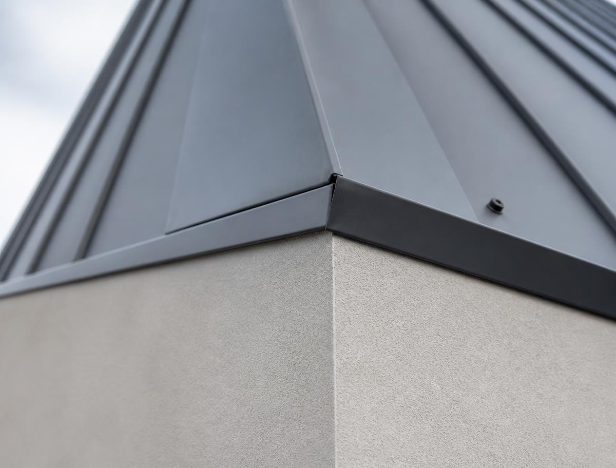 Detail des Übergangs zwischen Putzfassade und Metalldachkante